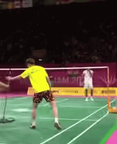 A Person In A Yellow Shirt Is Playing Badminton GIF