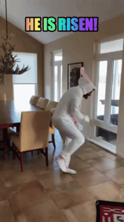A Person In An Easter Bunny Costume Is Jumping In A Room With The Words He Is Risen GIF