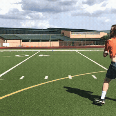 A Person In An Orange Shirt Is Running On A Football Field With The Letter O In The Background GIF