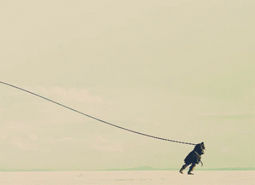 A Person Is Being Pulled By A Long Rope In The Desert GIF