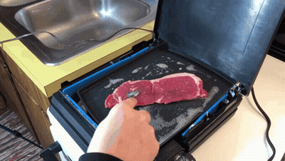 A Person Is Cooking A Steak On A Griddle In A Kitchen GIF