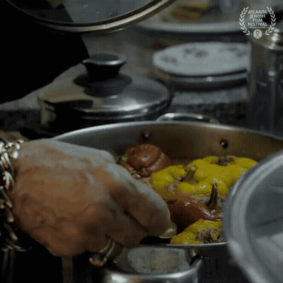 A Person Is Cooking Food In A Pot With A Laurel Wreath That Says Atlanta Documentary Film Festival GIF