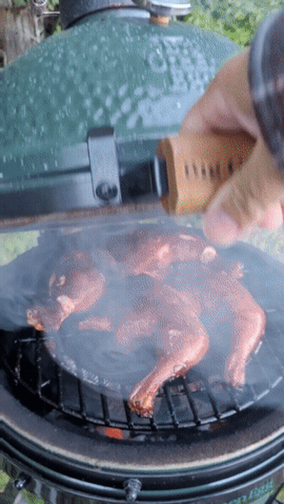 A Person Is Cooking Meat On A Big Green Egg GIF