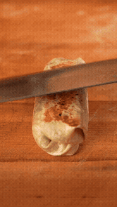 A Person Is Cutting A Burrito With A Knife That Says Han GIF