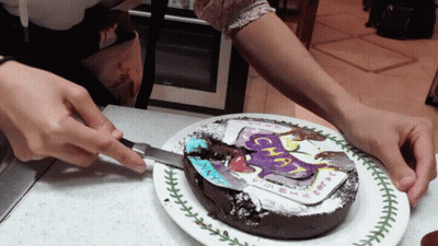 A Person Is Cutting A Chocolate Cake With A Picture Of A Unicorn On It GIF