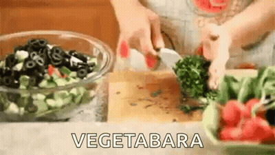A Person Is Cutting Vegetables On A Cutting Board . GIF