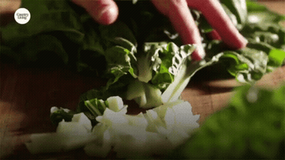 A Person Is Cutting Vegetables With A Country Living Logo GIF
