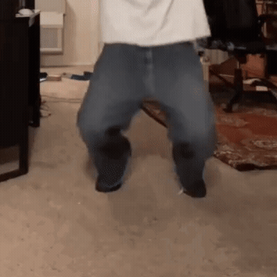 A Person Is Dancing In A Room With A Chair And A Desk In The Background . GIF