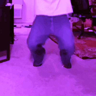 A Person Is Dancing In A Room With Purple Lighting GIF