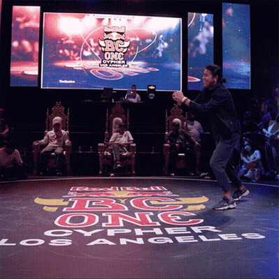 A Person Is Dancing In Front Of A Large Screen That Says Bc One Los Angeles GIF