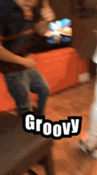 A Person Is Dancing In Front Of A Sign That Says Groovy On It GIF