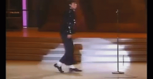 A Person Is Dancing On A Stage In Front Of A Microphone . GIF
