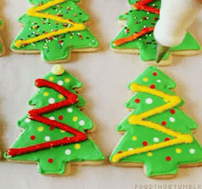 A Person Is Decorating Christmas Trees With Green Frosting GIF