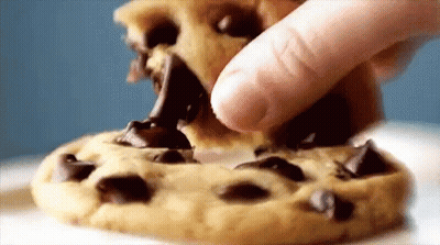 A Person Is Dipping A Chocolate Chip Cookie In Chocolate Sauce GIF