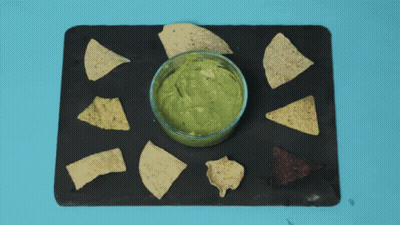 A Person Is Dipping Tortilla Chips Into Guacamole GIF