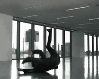 A Person Is Doing A Handstand In A Room With A Lot Of Windows GIF