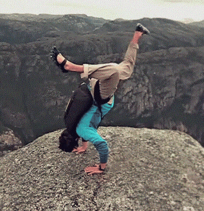 A Person Is Doing A Handstand On A Rocky Cliff . GIF