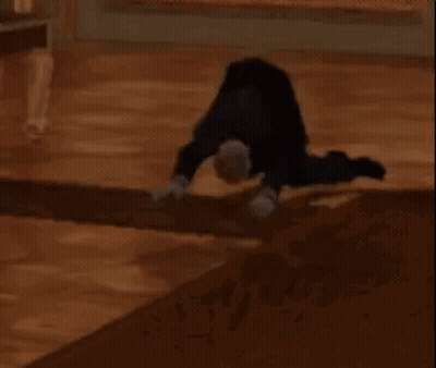 A Person Is Doing A Handstand On The Floor . GIF