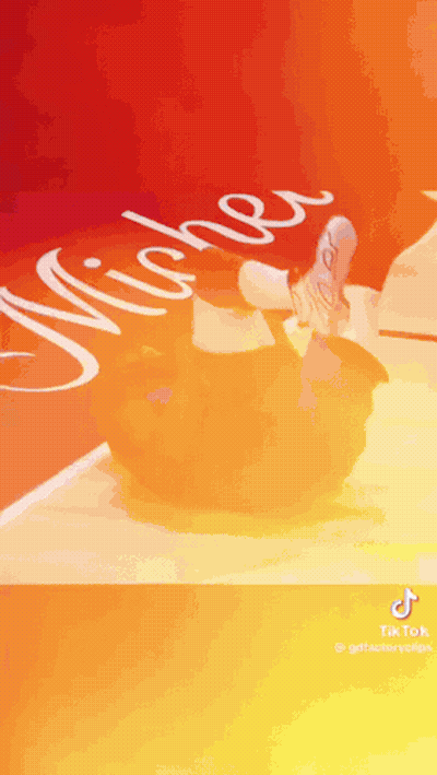 A Person Is Doing A Trick On A Basketball Court With The Word Michigan Written On It . GIF