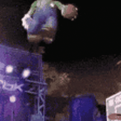 A Person Is Doing A Trick On A Trampoline In The Air At Night . GIF
