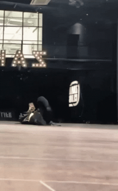 A Person Is Doing A Trick On The Floor In Front Of A Sign That Says " A & S " GIF