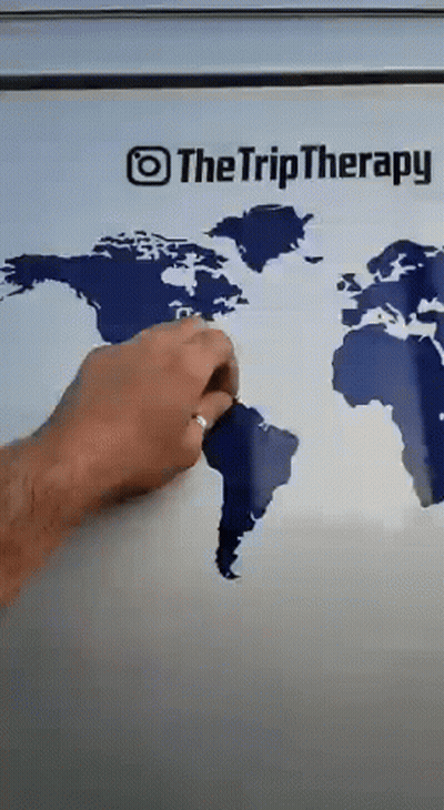A Person Is Drawing A Map Of The World On A Refrigerator Door GIF