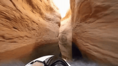 A Person Is Driving A Jet Ski Through A Canyon . GIF