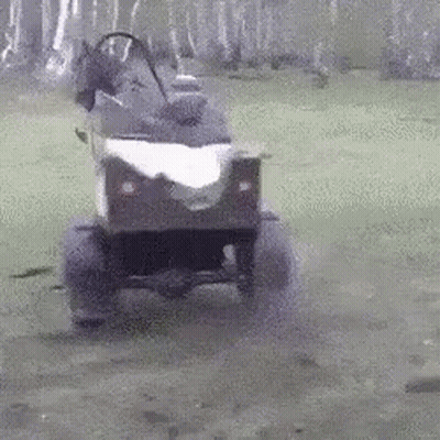 A Person Is Driving A Small Atv On A Muddy Road . GIF