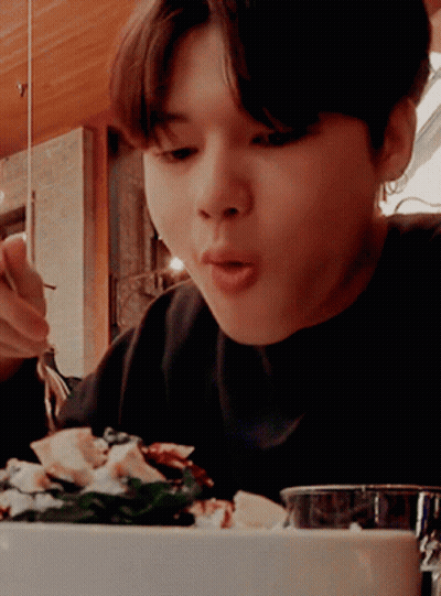 A Person Is Eating A Salad With A Fork And Spoon GIF