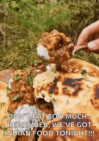 A Person Is Eating A Spoonful Of Food From A Plate Of Food . GIF
