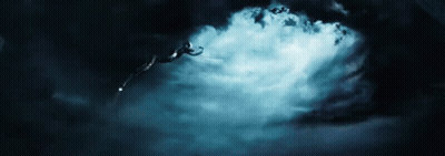 A Person Is Flying Through The Air In A Dark Cloudy Sky . GIF