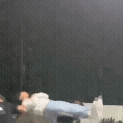 A Person Is Flying Through The Air While A Group Of People Watch . GIF
