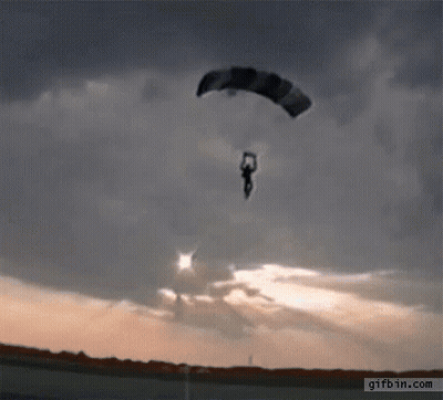 A Person Is Flying Through The Air With A Parachute And The Website Gifbin.com Is Visible In The Corner GIF