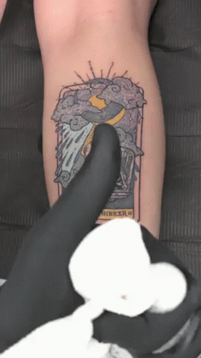 A Person Is Getting A Tattoo On Their Leg That Says ' Thinker ' GIF