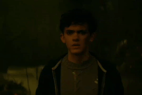A Person Is Glowing In The Dark With A Blue Light Behind Them GIF