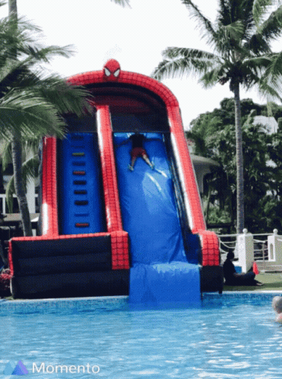 A Person Is Going Down An Inflatable Spider Man Slide GIF