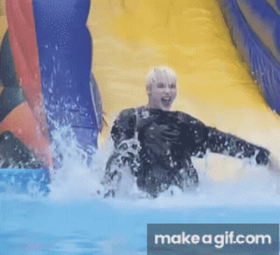 A Person Is Going Down An Inflatable Water Slide With Make A Gif.com In The Corner GIF