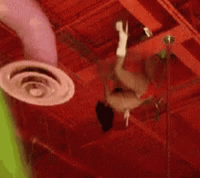 A Person Is Hanging From The Ceiling Of A Building GIF