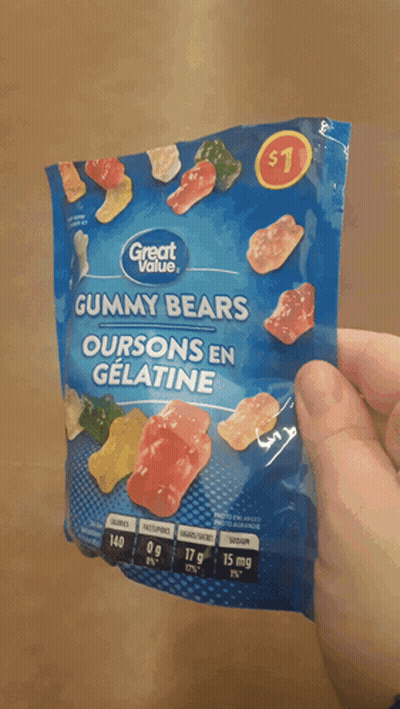 A Person Is Holding A Bag Of Gummy Bears That Cost $ 1 GIF