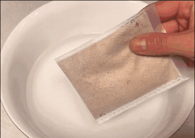 A Person Is Holding A Bag Over A Bowl Of Liquid GIF