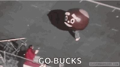 A Person Is Holding A Balloon That Looks Like A Poop With A Face On It . GIF