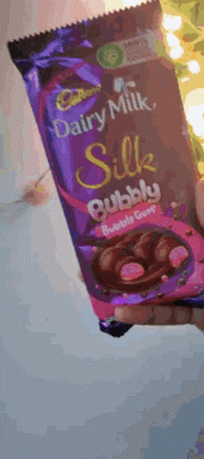 A Person Is Holding A Bar Of Cadbury Dairy Milk Silk Bubble Gum Chocolate GIF