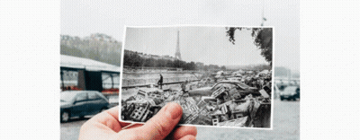 A Person Is Holding A Black And White Photo Of A Pile Of Cars In Front Of The Eiffel Tower GIF