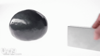 A Person Is Holding A Block Next To A Black Ball And A Vat19.com Logo GIF