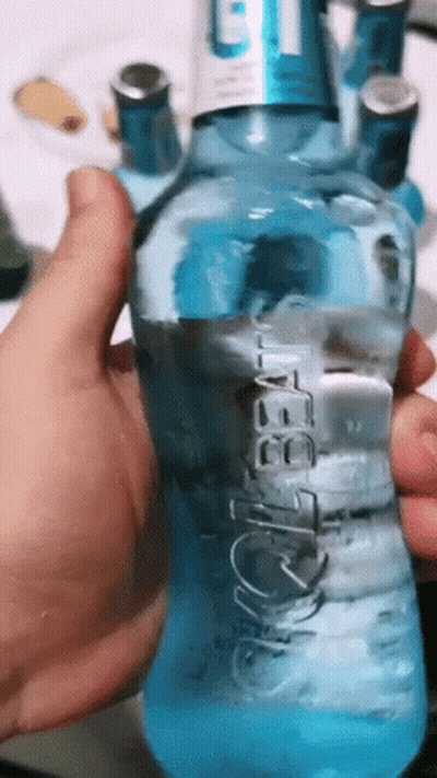 A Person Is Holding A Blue Bottle Of Aquafina GIF
