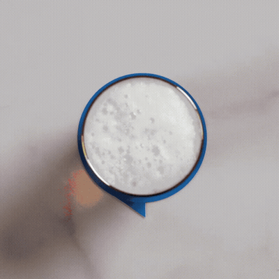 A Person Is Holding A Blue Speech Bubble With Foam On Top GIF