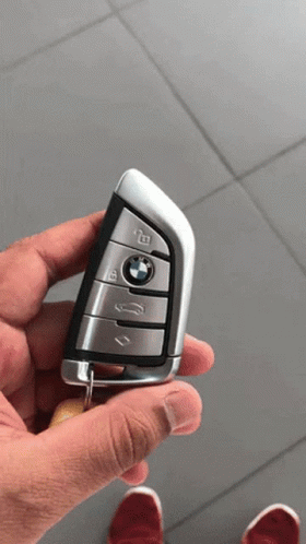 A Person Is Holding A Bmw Remote Control In Their Hand GIF