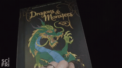 A Person Is Holding A Book With A Picture Of A Plant On It . GIF