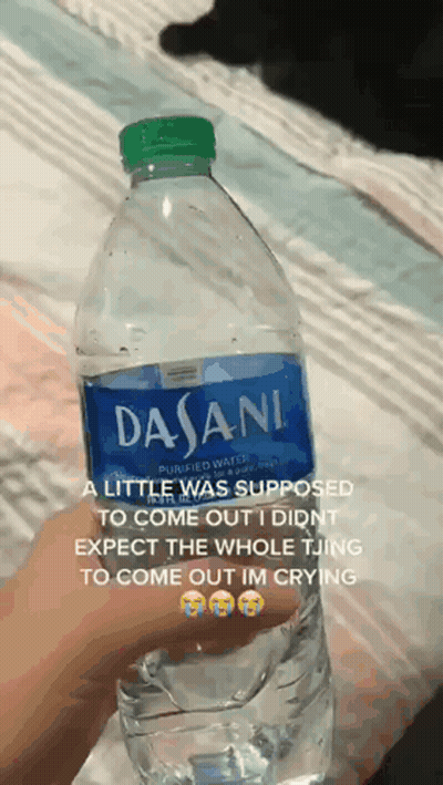 A Person Is Holding A Bottle Of Dasani Water In Their Hand GIF