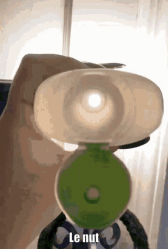 A Person Is Holding A Bottle With The Word Le Nut Written On It GIF